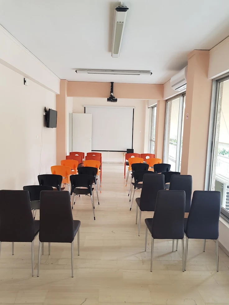 Αίθουσα σεμιναρίων με καθίσματα και οθόνη προβολής